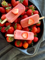 Flat lay overhead of red strawberry popsicles on fresh strawberries in an artisanal ceramic dish Flat lay overhead of red strawberry popsicles on fresh strawberries in an artisanal ceramic dish - PhotoDune Item for Sale