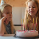 little girls, sisters, twins happily blew out the candles on the birthday cake at home festive cap little girls, sisters, twins happily blew out the candles on the birthday cake at home festive cap - PhotoDune Item for Sale