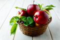 Ripe apples with leaves in the basket on wooden table Ripe apples with leaves in the basket on wooden table - PhotoDune Item for Sale