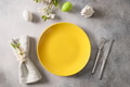Easter festive table setting with yellow plate, spring flowers and green colorful eggs. Easter festive table setting with yellow plate, spring flowers and green colorful eggs. - PhotoDune Item for Sale