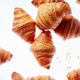 Falling fresh french croissants with crumbs on a light background Falling fresh french croissants with crumbs on a light background - PhotoDune Item for Sale