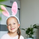 Smiling young girl wearing bunny ears headband at home Smiling young girl wearing bunny ears headband at home - PhotoDune Item for Sale