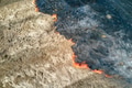 Aerial view of grassland field burning with red fire during dry season. Natural disaster and climate Aerial view of grassland field burning with red fire during dry season. Natural disaster and climate - PhotoDune Item for Sale