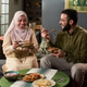 Young Muslim Woman and Young Muslim Man Enjoying Meal Together Indoors Young Muslim Woman and Young Muslim Man Enjoying Meal Together Indoors - PhotoDune Item for Sale