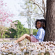 African Girl Relaxing Under Tree Surrounded by Pink Blossoms in Spring Park African Girl Relaxing Under Tree Surrounded by Pink Blossoms in Spring Park - PhotoDune Item for Sale