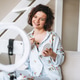 Young woman blogger in home clothes doing makeup with mobile phone and ring lamp online in studio Young woman blogger in home clothes doing makeup with mobile phone and ring lamp online in studio - PhotoDune Item for Sale