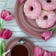 Spring layout with pink tulips, a cup of tea and pink donuts on a light background Spring layout with pink tulips, a cup of tea and pink donuts on a light background - PhotoDune Item for Sale