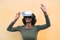 Happy Afro woman using virtual reality headset outdoor Happy Afro woman using virtual reality headset outdoor - PhotoDune Item for Sale