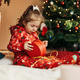 Little girl opens a Christmas present near the Christmas tree Little girl opens a Christmas present near the Christmas tree - PhotoDune Item for Sale