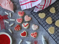 Flat lay of valentines heart cookies being baked and baking utensils on gray background Flat lay of valentines heart cookies being baked and baking utensils on gray background - PhotoDune Item for Sale