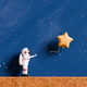 Astronaut reaching for a star shaped balloon Astronaut reaching for a star shaped balloon - PhotoDune Item for Sale