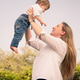 A mother with her baby son holding up against sky snd enjoying mother children moment. A mother with her baby son holding up against sky snd enjoying mother children moment. - PhotoDune Item for Sale