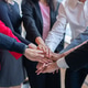 Diverse group of professionals in business attire stacking hands in a show of unity and teamwork Diverse group of professionals in business attire stacking hands in a show of unity and teamwork - PhotoDune Item for Sale
