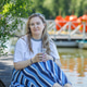 A blonde woman drinks iced tea in a park by a lake. Summer, outdoor recreation. A blonde woman drinks iced tea in a park by a lake. Summer, outdoor recreation. - PhotoDune Item for Sale
