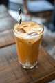 Side view of a ice latte coffee with a straw on a wooden table Side view of a ice latte coffee with a straw on a wooden table - PhotoDune Item for Sale