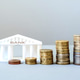 Model of a bank building with growing stacks of coins, financial growth Model of a bank building with growing stacks of coins, financial growth - PhotoDune Item for Sale