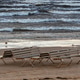 Empty beach chairs on Jurmala shore with waves crashing under cloudy sky Empty beach chairs on Jurmala shore with waves crashing under cloudy sky - PhotoDune Item for Sale