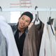 Smiling Young Muslim Man Browsing Clothes On Rack Finding Best Outfit For Eid Lebaran Smiling Young Muslim Man Browsing Clothes On Rack Finding Best Outfit For Eid Lebaran - PhotoDune Item for Sale