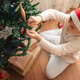 Child wearing Santa's hat decorating Christmas tree sitting on the floor. Child wearing Santa's hat decorating Christmas tree sitting on the floor. - PhotoDune Item for Sale
