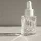 Close-up of a clear glass bottle with a moisturizing serum and a pipette in bright sunlight Close-up of a clear glass bottle with a moisturizing serum and a pipette in bright sunlight - PhotoDune Item for Sale