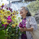 An Asian senior woman smiles while selecting fresh flowers at a market An Asian senior woman smiles while selecting fresh flowers at a market - PhotoDune Item for Sale