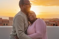 Happy Latin senior couple having romantic moment embracing on rooftop during sunset time Happy Latin senior couple having romantic moment embracing on rooftop during sunset time - PhotoDune Item for Sale