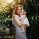 Mother with baby in arms in garden Mother with baby in arms in garden - PhotoDune Item for Sale