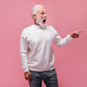 Shocked man in white sweater pointing to place for text. Surprised adult guy in eyeglasses and mode Shocked man in white sweater pointing to place for text. Surprised adult guy in eyeglasses and mode - PhotoDune Item for Sale