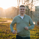 Beautiful happy 35 year old caucasian man jogs in an autumn park at sunset Beautiful happy 35 year old caucasian man jogs in an autumn park at sunset - PhotoDune Item for Sale