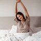 Happy woman stretching in bed after waking up, morning routine and healthy lifestyle Happy woman stretching in bed after waking up, morning routine and healthy lifestyle - PhotoDune Item for Sale