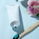 Toothpaste tube with toothbrush on background Toothpaste tube with toothbrush on background - PhotoDune Item for Sale