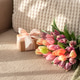 Tulip Bouquet and Gift Box on Cozy Sofa. Warm Spring Flatlay with Soft Textures Tulip Bouquet and Gift Box on Cozy Sofa. Warm Spring Flatlay with Soft Textures - PhotoDune Item for Sale