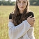 Young woman with long brown hair standing in rye field under soft daylight Young woman with long brown hair standing in rye field under soft daylight - PhotoDune Item for Sale