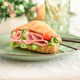 Croissant sandwich filled with ham, lettuce, tomato, and rolled cucumber slices Croissant sandwich filled with ham, lettuce, tomato, and rolled cucumber slices - PhotoDune Item for Sale