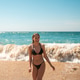 Cheerful sensuous woman in black bikini walking on seashore at beach Cheerful sensuous woman in black bikini walking on seashore at beach - PhotoDune Item for Sale
