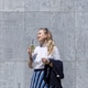 A blonde woman drinks a mojito and talks on the phone in the city in summer. A blonde woman drinks a mojito and talks on the phone in the city in summer. - PhotoDune Item for Sale