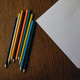 multi-colored pencils and a white a4 sheet on a wooden background multi-colored pencils and a white a4 sheet on a wooden background - PhotoDune Item for Sale