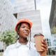 Happy black woman in helmet standing with coffee cup in daylight Happy black woman in helmet standing with coffee cup in daylight - PhotoDune Item for Sale