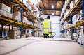 Male warehouse worker pulling a pallet truck. Male warehouse worker pulling a pallet truck. - PhotoDune Item for Sale