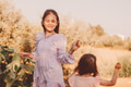 Two little girls wearing boho style dresses playing together in cacti garden. Kids having fun Two little girls wearing boho style dresses playing together in cacti garden. Kids having fun - PhotoDune Item for Sale