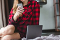 Beautiful woman in checkered shirt using cell phone and laptop Beautiful woman in checkered shirt using cell phone and laptop - PhotoDune Item for Sale