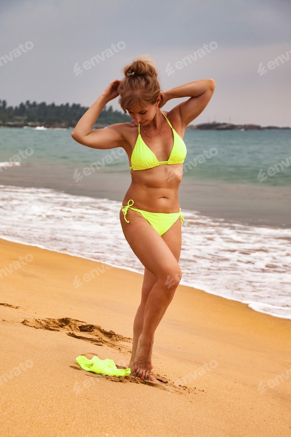 Full length of middle aged lady 50 year old in yellow swimsuit