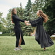 Two young women dancing outdoors on green lawn with trees Two young women dancing outdoors on green lawn with trees - PhotoDune Item for Sale