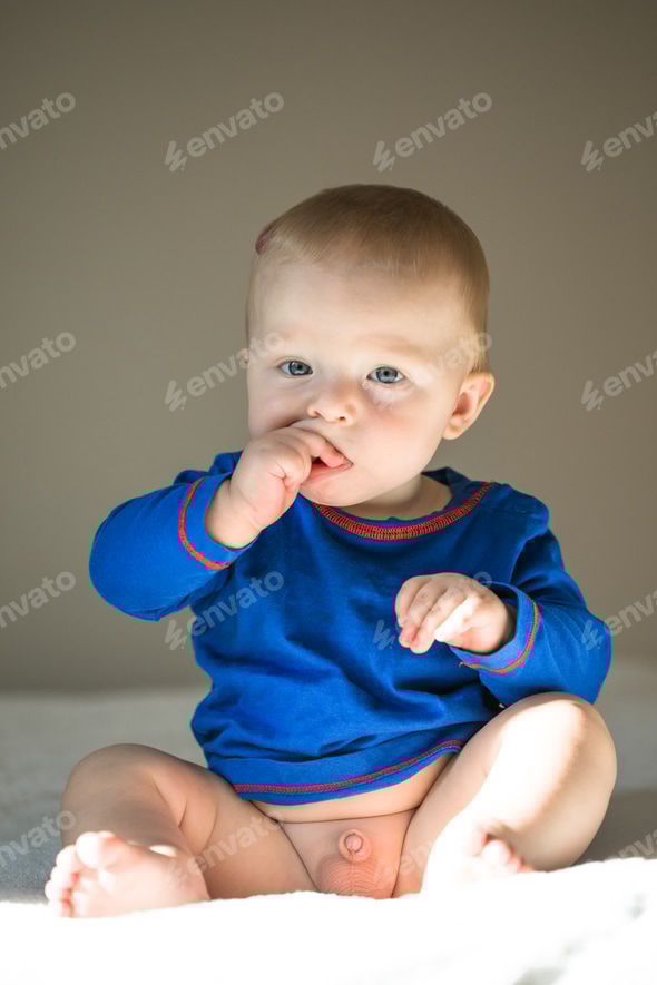 Cute smiling Cute month old Baby boy infant on a bed