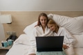 Two sisters in bathrobes are sitting on the bed in the hotel and watching movie on laptop. Two sisters in bathrobes are sitting on the bed in the hotel and watching movie on laptop. - PhotoDune Item for Sale