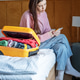 Woman using phone near luggage in hotel room Woman using phone near luggage in hotel room - PhotoDune Item for Sale