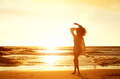 Silhouette young woman walking on beach during sunset Silhouette young woman walking on beach during sunset - PhotoDune Item for Sale