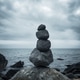 A pile of balanced stones on a moody seashore A pile of balanced stones on a moody seashore - PhotoDune Item for Sale