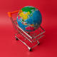Colorful globe resting inside a miniature shopping cart Colorful globe resting inside a miniature shopping cart - PhotoDune Item for Sale