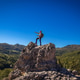 Hiker atop a rock in the wilderness Hiker atop a rock in the wilderness - PhotoDune Item for Sale